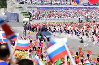 people cheering as North Korea’s leader Kim Jong Un (centre R) and Russia’s President Vladimir Putin (centre L) parade around in an open-top car during a welcoming ceremony at Kim Il Sung Square in Pyongyang